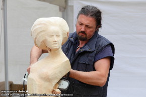 Roberto Merotto rifinisce la sua scultura in legno.